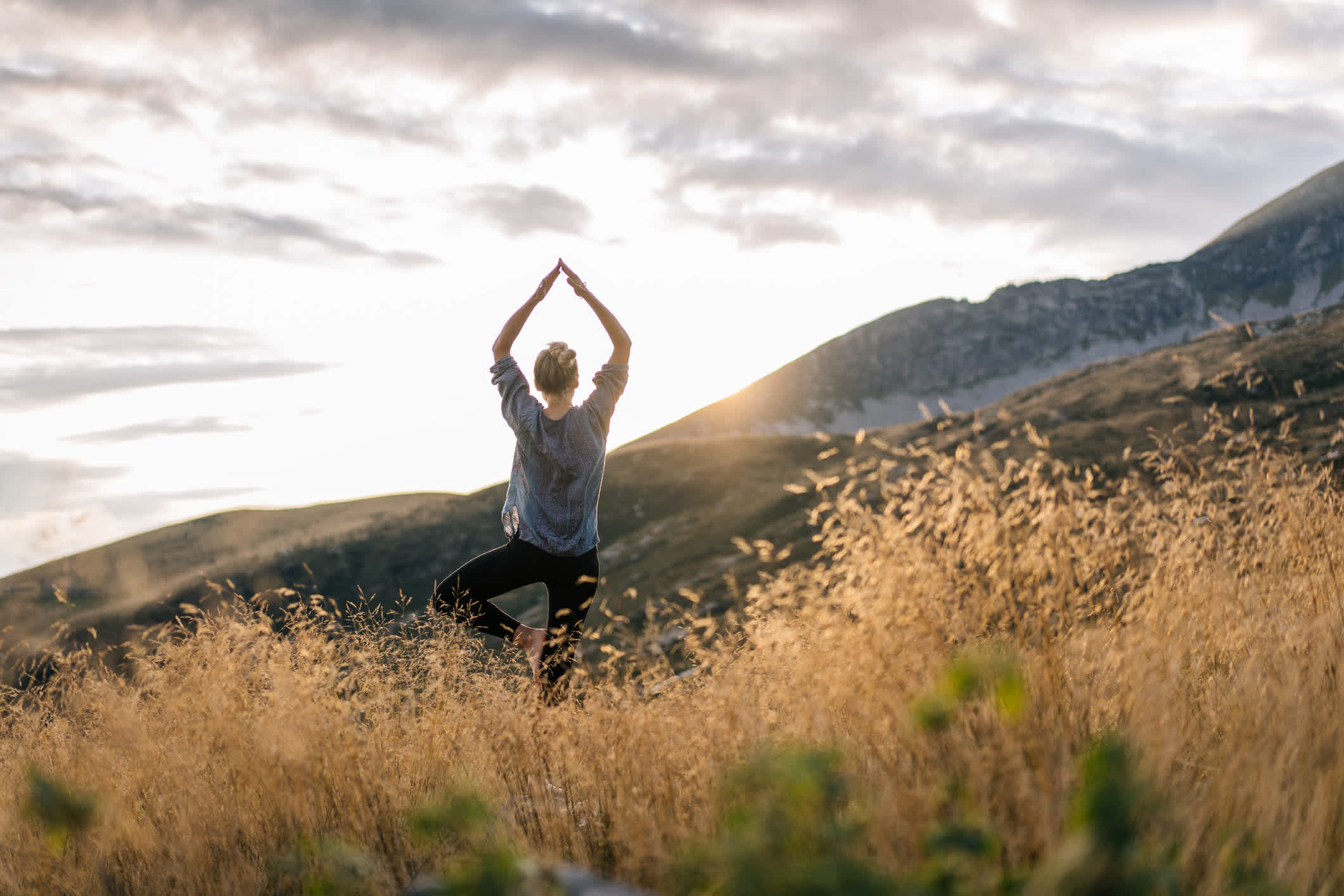 Junge Frau praktiziert Yoga im Morgenlicht