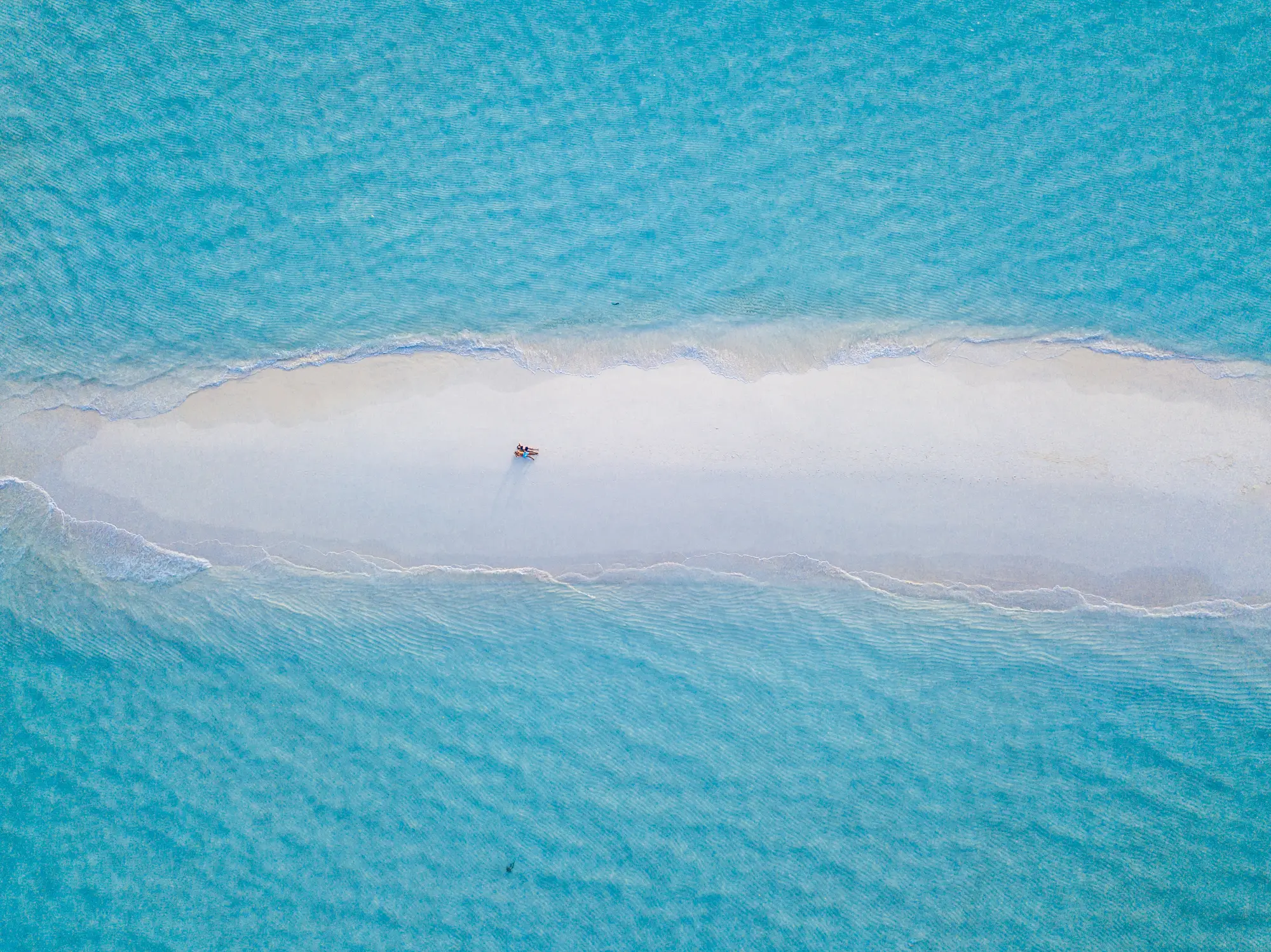 Malediven, Baa Atoll Paar liegt zusammen auf einer Sandbank zwischen türkisfarbenem Wasser auf den Malediven.