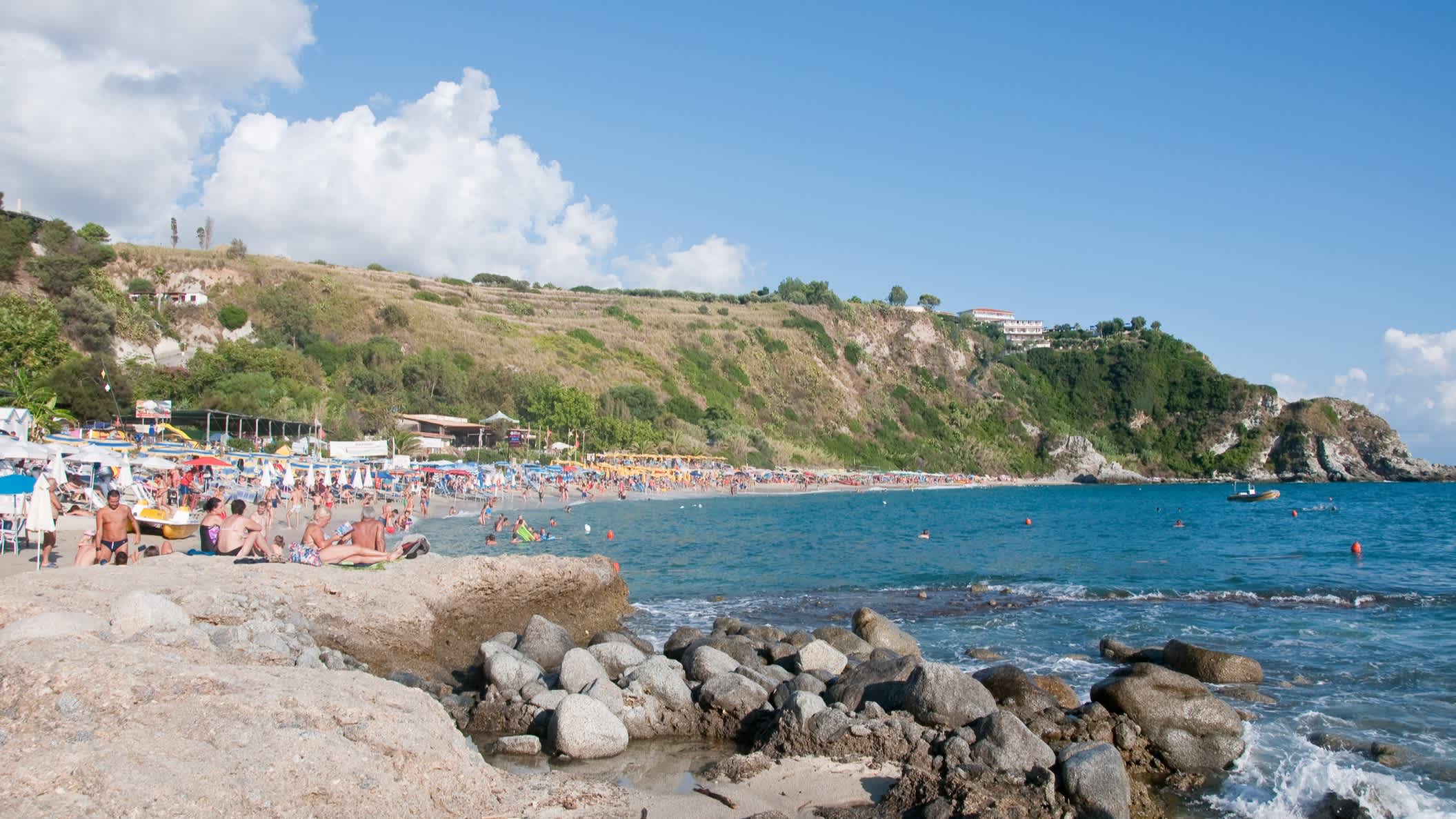 Persones sur des rochers au bord de la plage de Grotticelle, en Calabre, en Italie.