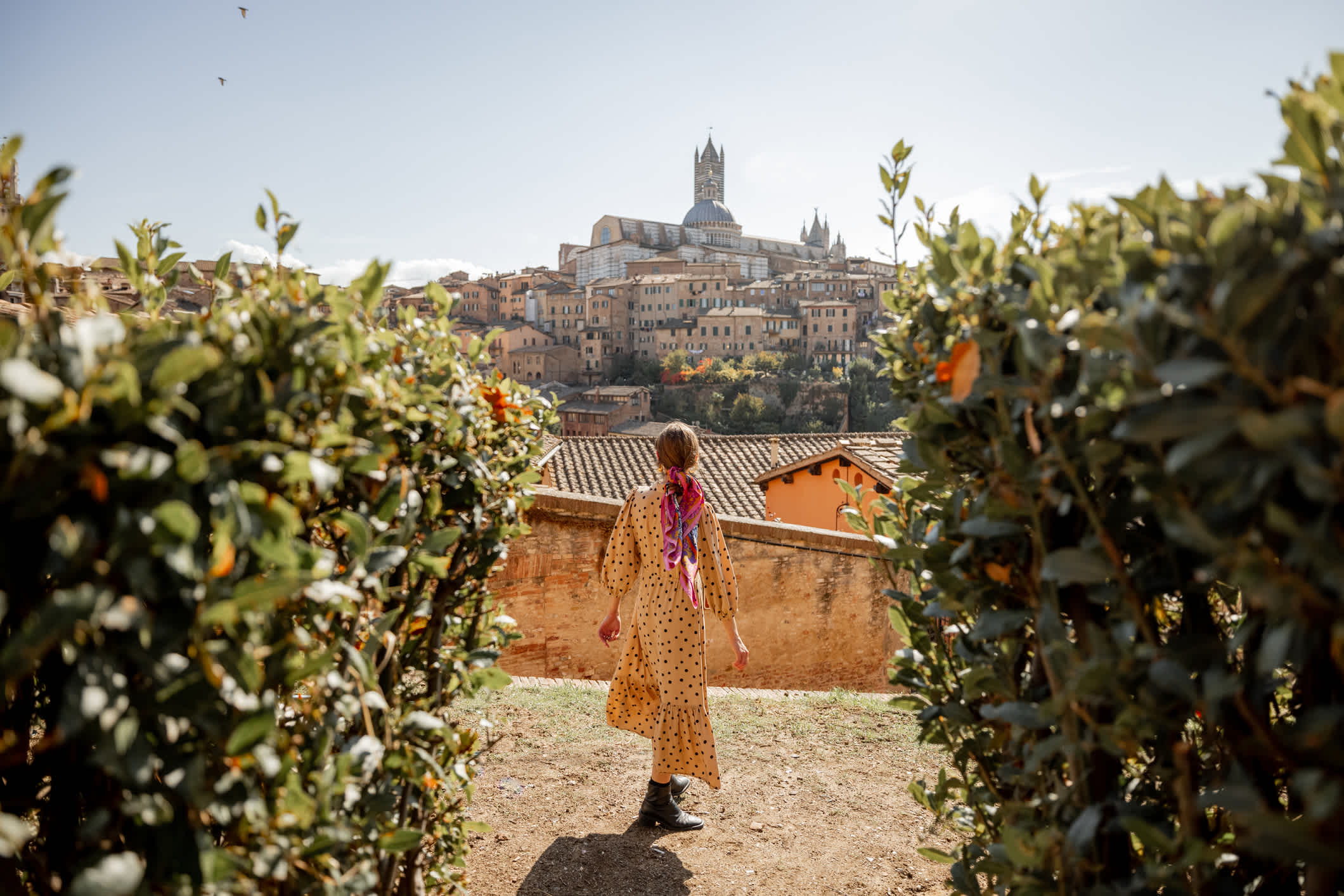 Une femme devant le panorama de la ville de Sienne