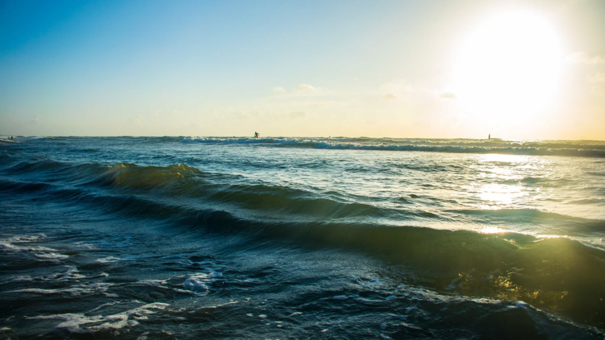 Strand auf Padre Island, Texas, USA bei blauem Himmel und Sonne mit Blick auf die Wellen.