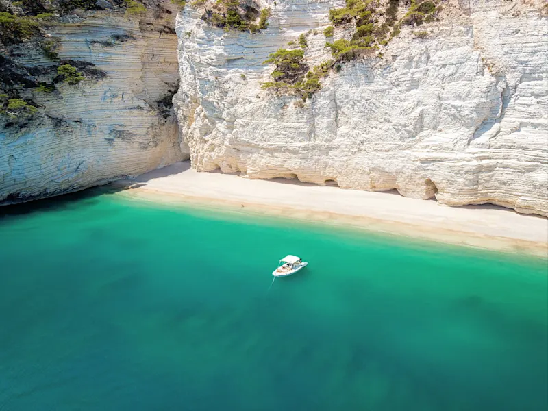 Kleines Boot auf dem türkisfarbenen Wasser des Naturparks Gargano