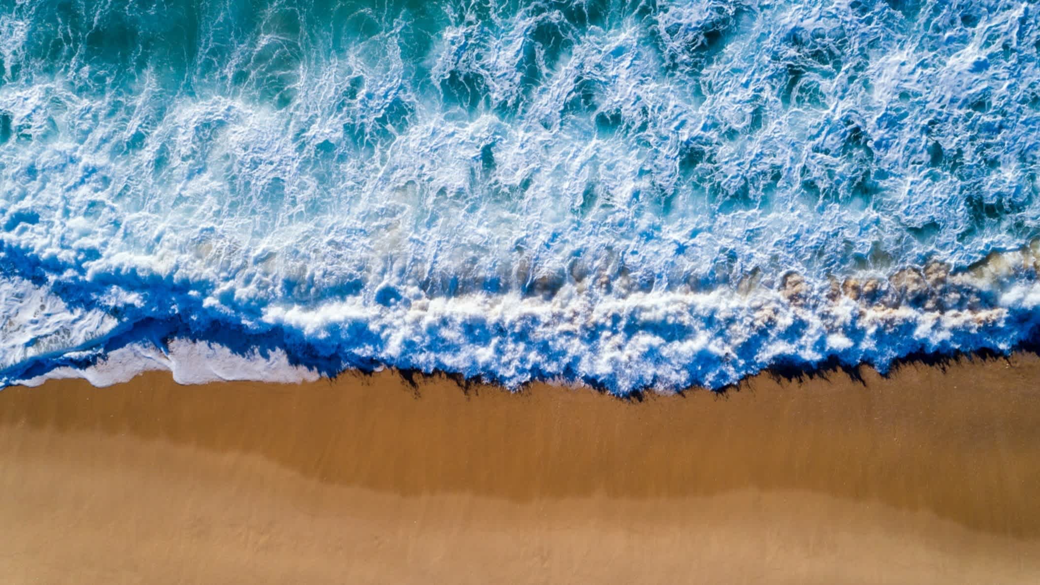 Eine Welle am Ufer der Praia da Comporta innAlentejo, Portugal. 