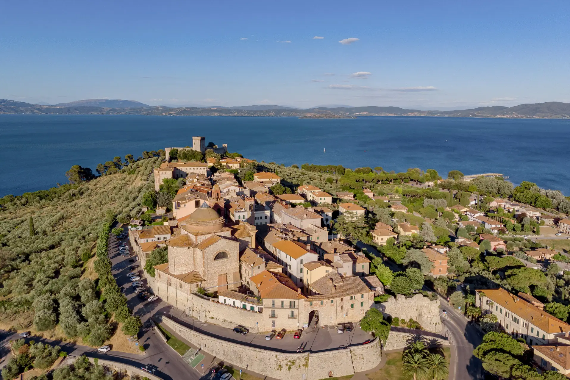 Village with old town walls on a hill overlooking Lago Trasimeno, the largest lake in Umbria