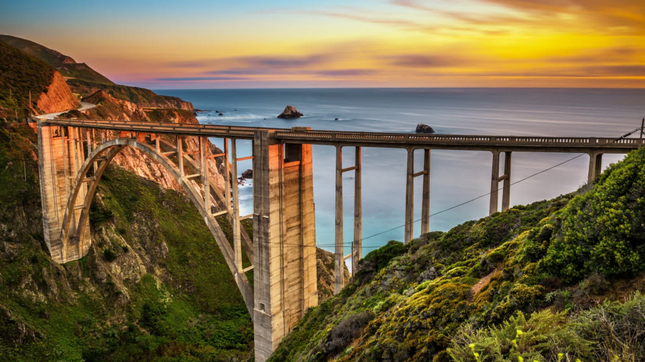 Bixby Bridge (Rocky Creek Bridge) und Pacific Coast Highway bei Sonnenuntergang in der Nähe von Big Sur in Kalifornien, USA.
