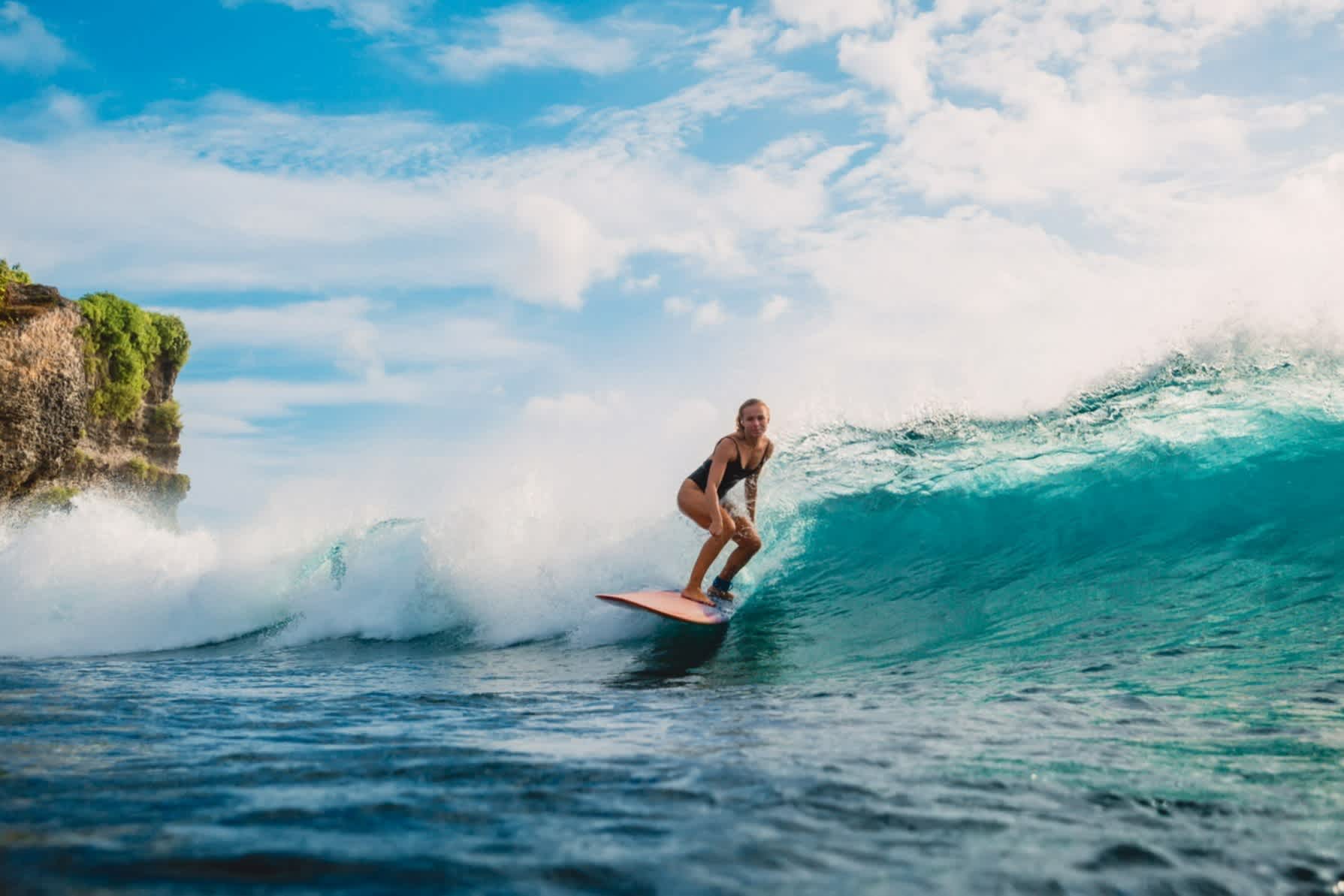 La fille sur une planche de surf à Bali, Indonésie

