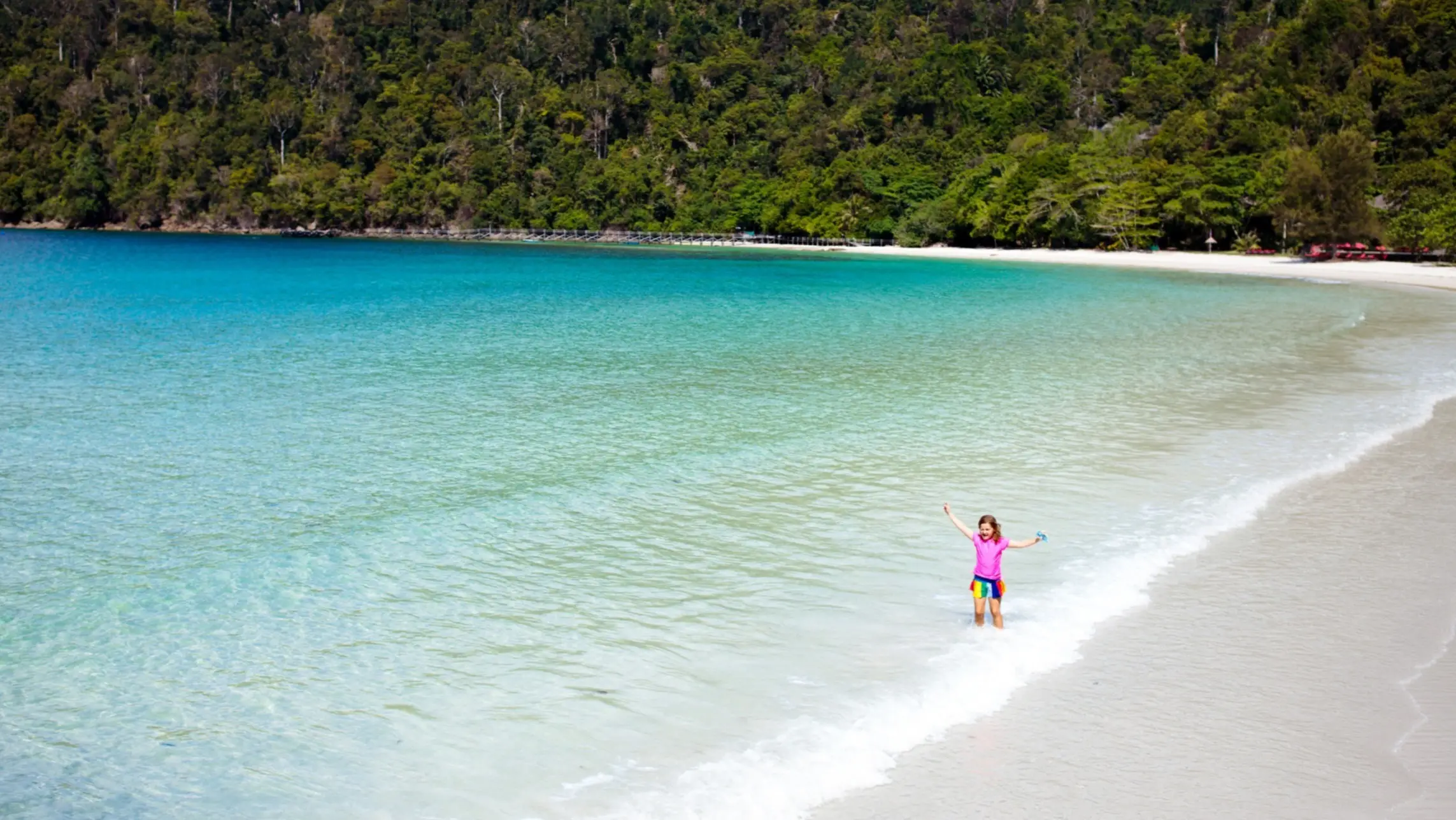 Coral Beach, île de Pangkor, Malaisie Fille les pieds dans l'eau au bord de la plage de Coral Beach à Pangkor, en Malaisie.