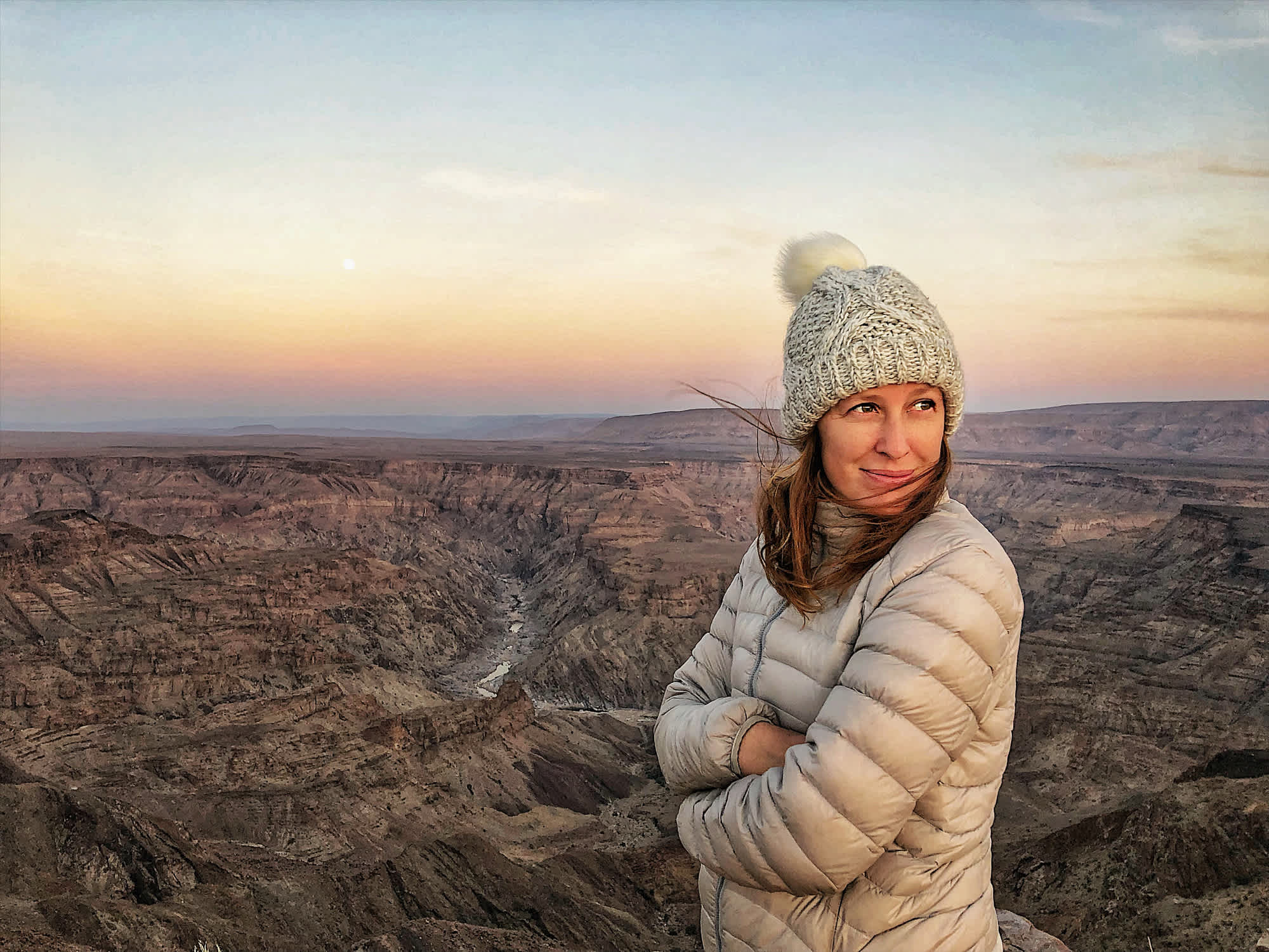 Femme qui voyage seule en Namibie et admire la vue sur le Fish River Canyon au coucher du soleil. Étude Tourlane - Ifop sur le voyage solo et les femmes.