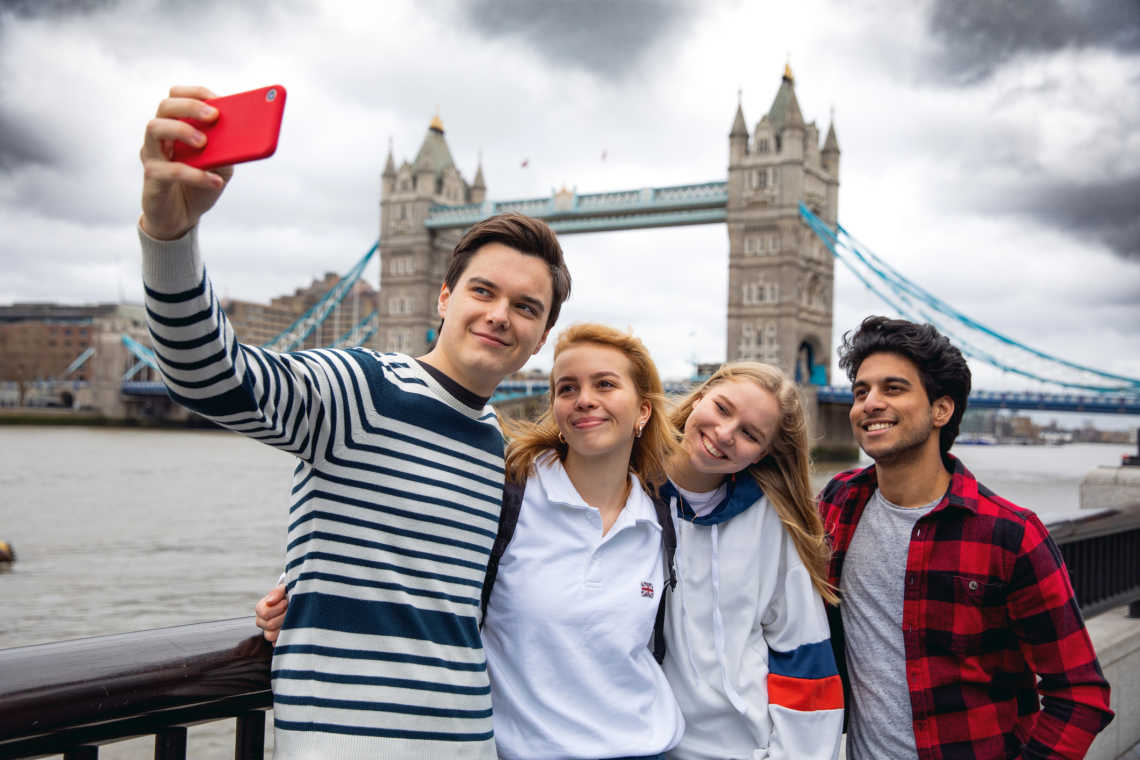 Teenager-Freunde zu Besuch in London auf der Tower Bridge, England. 

