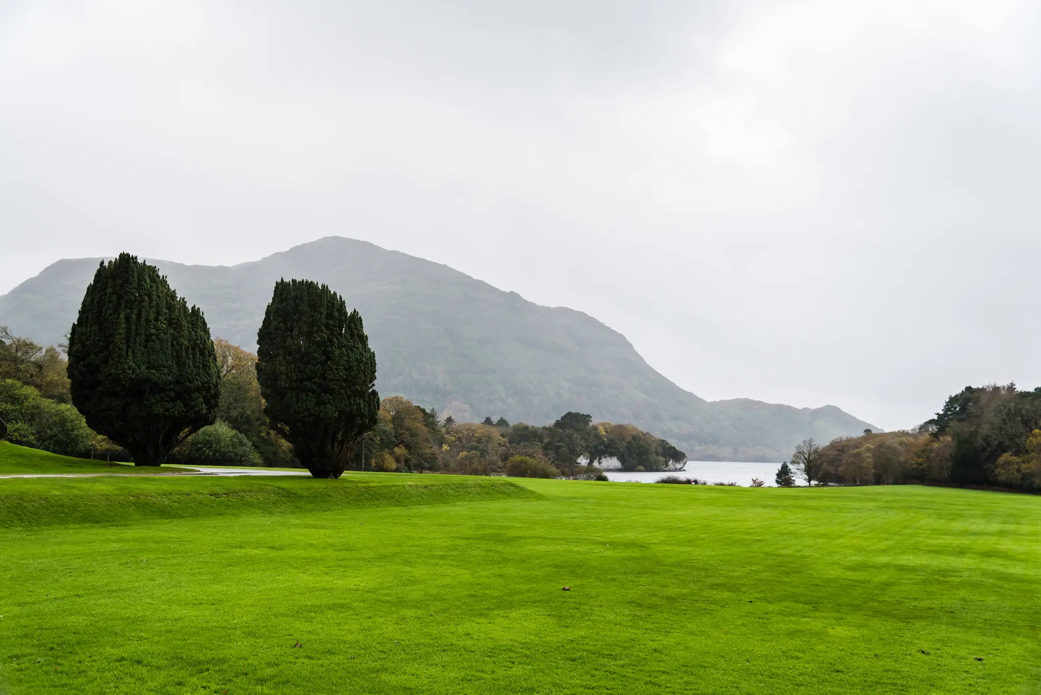 Irland, Kerry, Golfen Saftig-grüne Rasenfläche mit See und Berg im Hintergrund