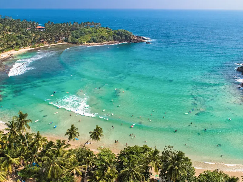 Hiriketiya Beach, Sri Lanka Hiriketiya Beach in Sri Lanka ist ein malerischer, halbmondförmiger Strand, ideal zum Surfen und Entspannen, umgeben von üppiger Natur und ruhigem Wasser