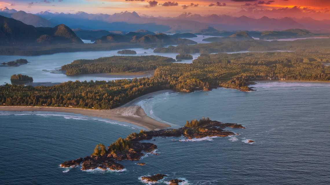 Luftaufnahme der kanadischen Landschaft an der Westpazifikküste während eines farbenprächtigen Sonnenuntergangs. Aufgenommen in Tofino, Vancouver Island, British Columbia, Kanada.