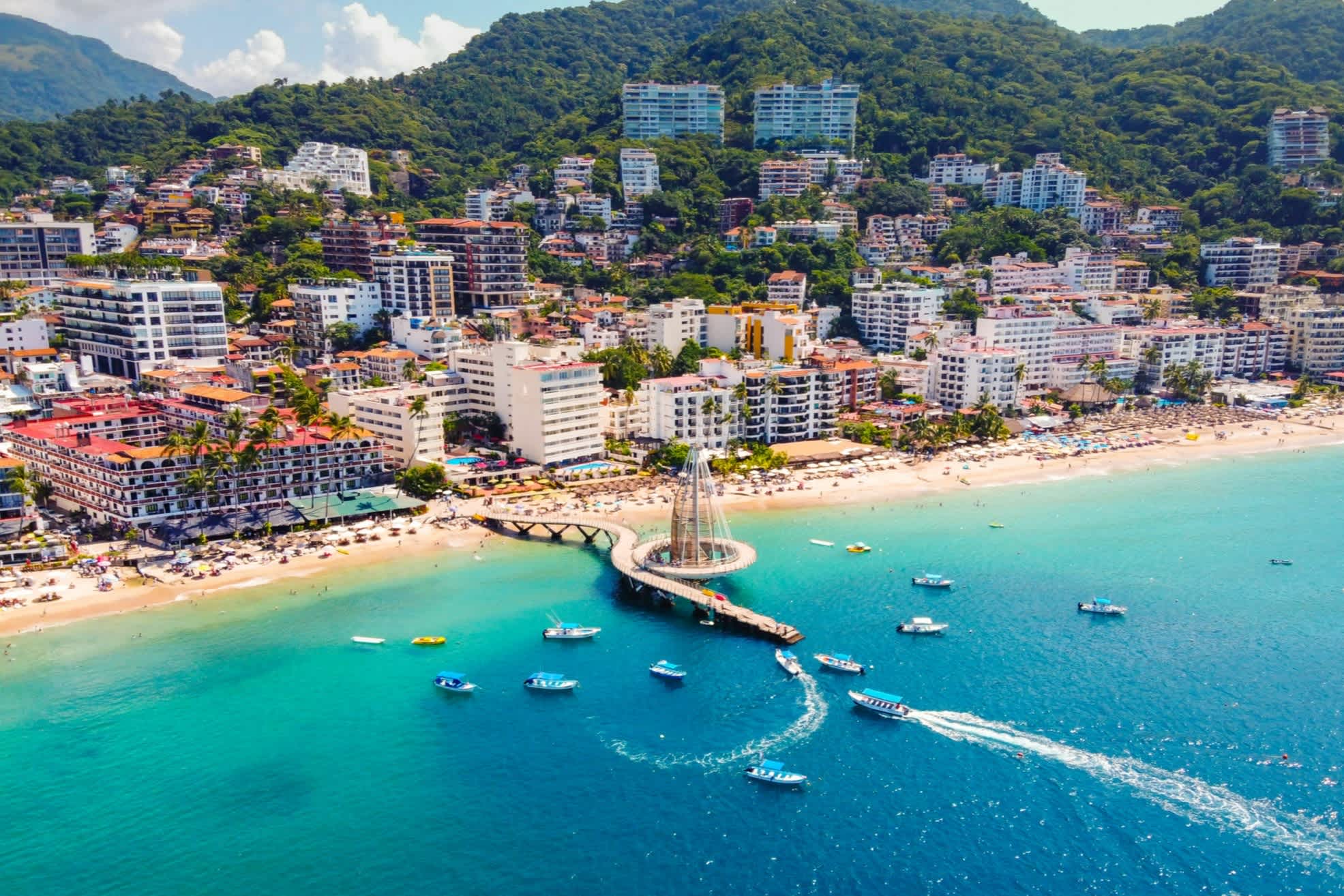 Luftaufnahme eines Strandabschnitts in Puerto Vallarta mit türkisblauem Meer und Badeurlaubern