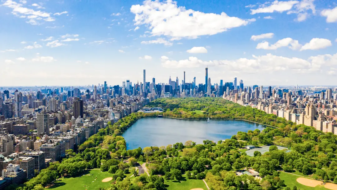 Central Park mit Skyline unter blauem Himmel. New York City, New York, USA