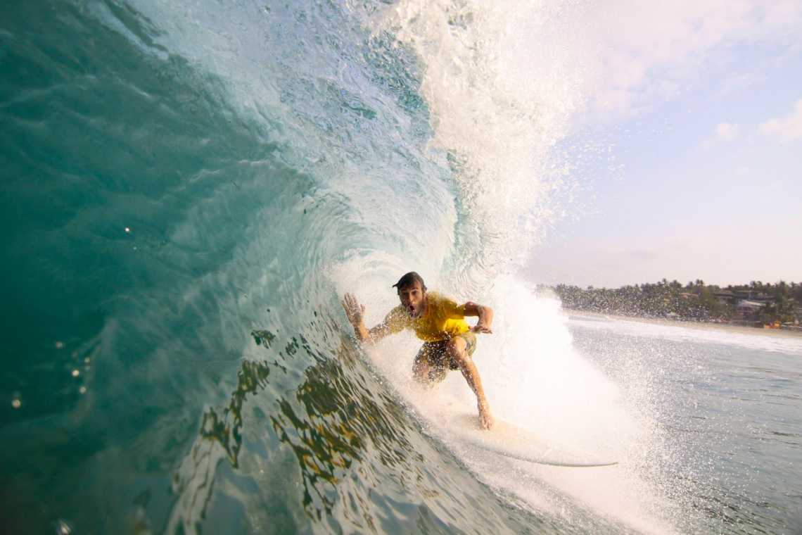 Mann reitet Wellen auf Surfboard.