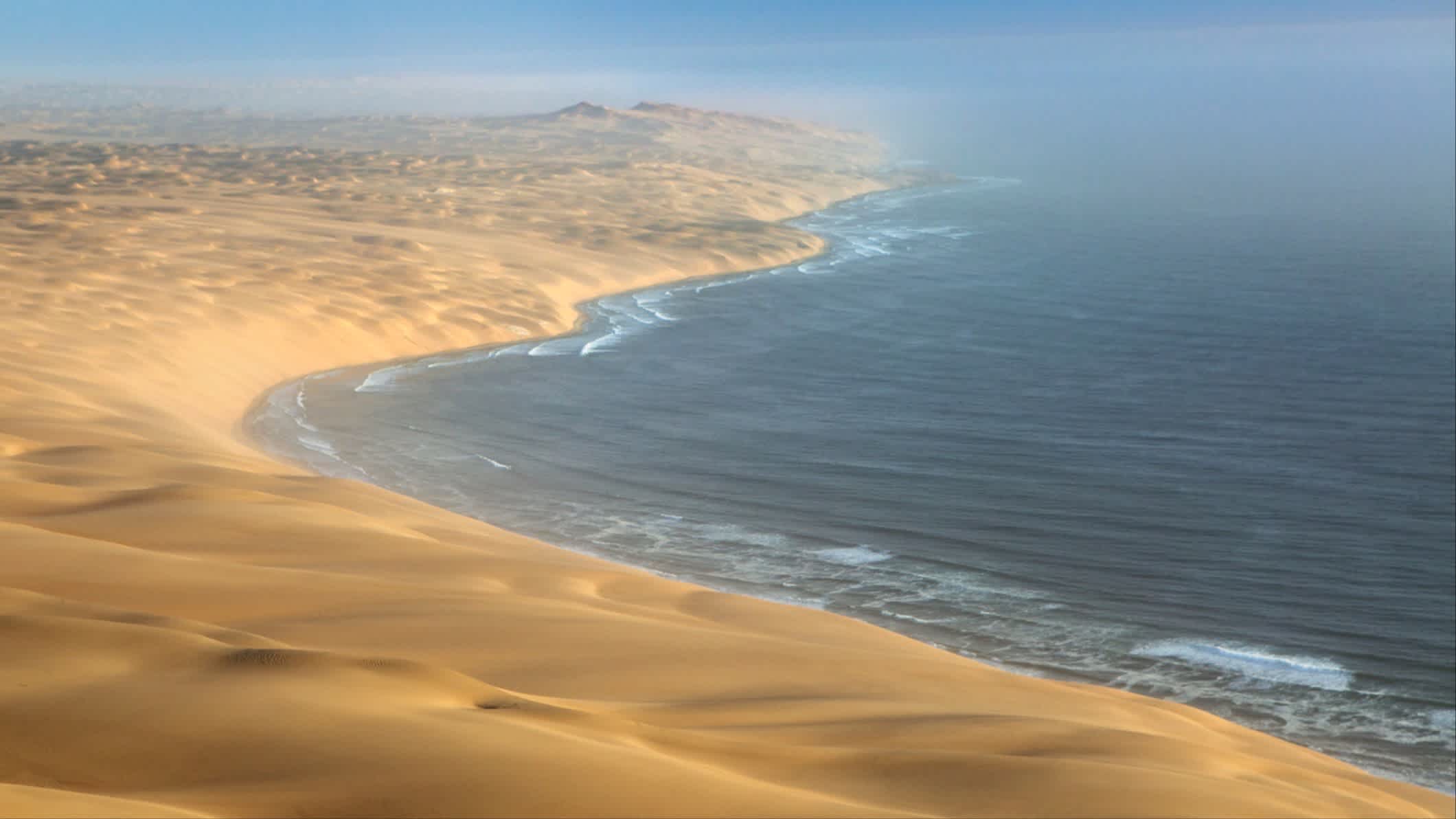 Eine Luftaufnahme der imposanten Dünen-Küste Sossusvlei Namibias mit dem weiten Ozean im Bild.