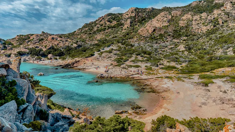 Turquoise water and rocky coastline on a beach. Costa Smeralda, Sardinia, Italy.