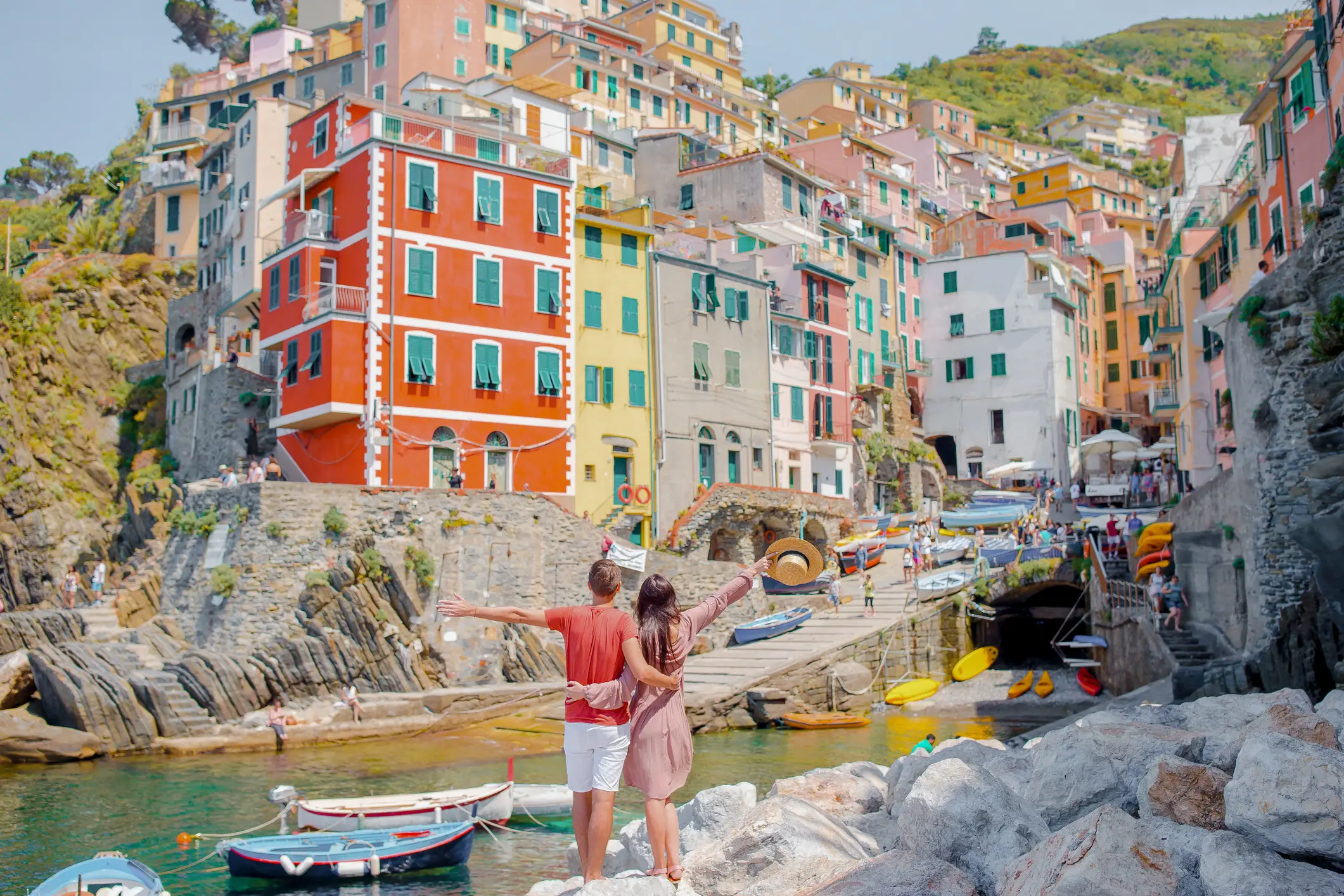 Touristen betrachten die malerische Aussicht auf Riomaggiore, Cinque Terre, Ligurien, Italien