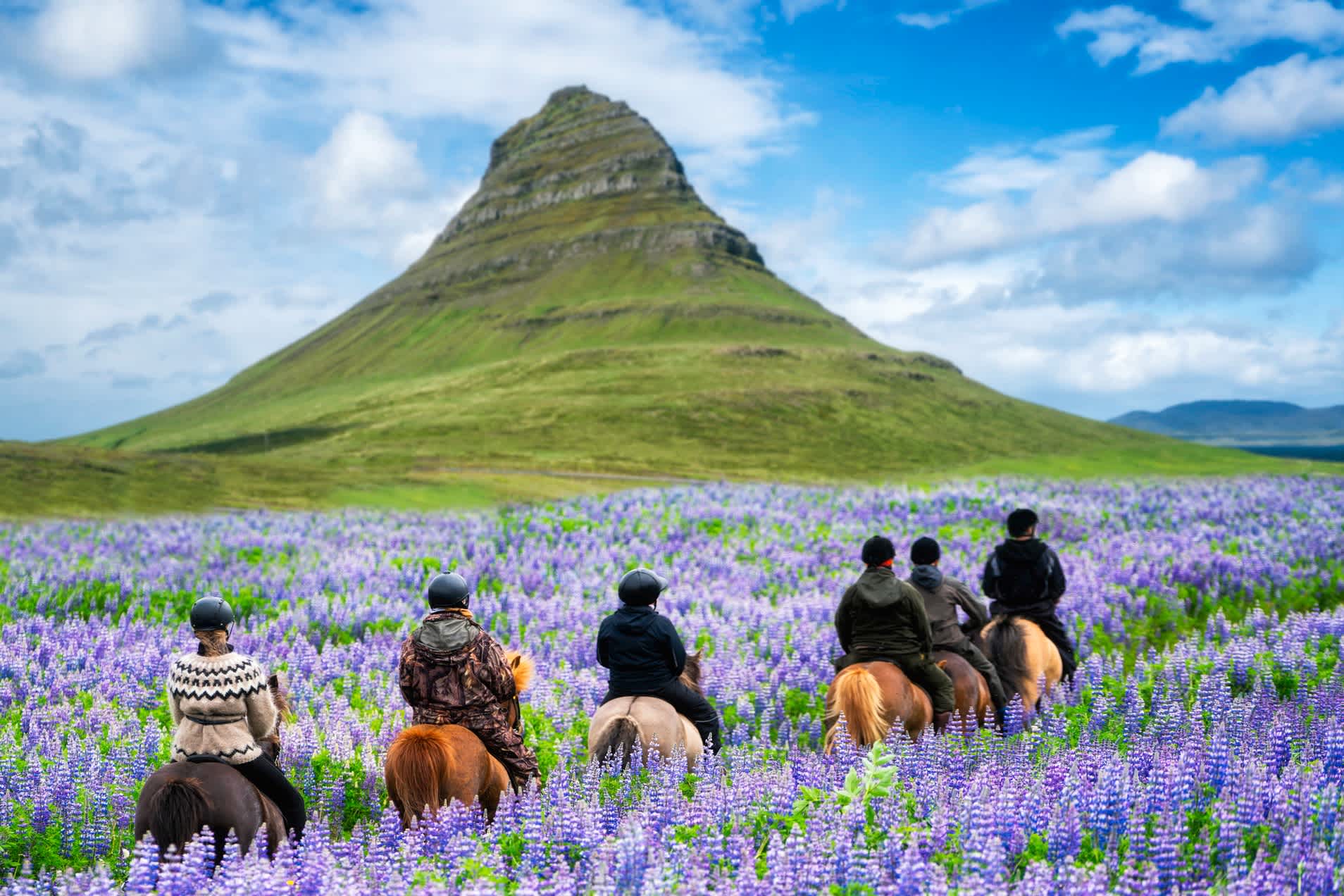 Tourist reitet Pferd in Kirkjufell Berglandschaft in Island.
