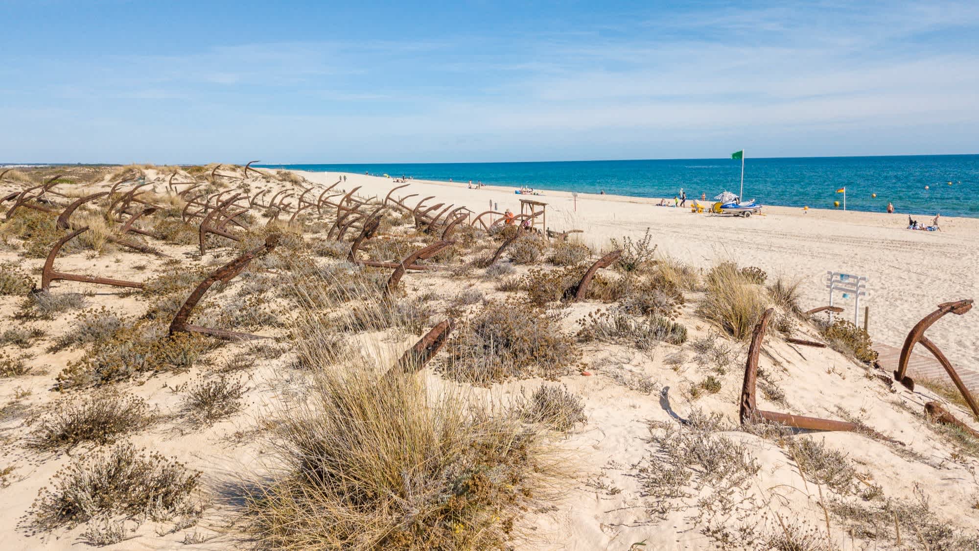 Dunes de sable blanc au bord de l'eau claire sur la plage de Barril au Portugal