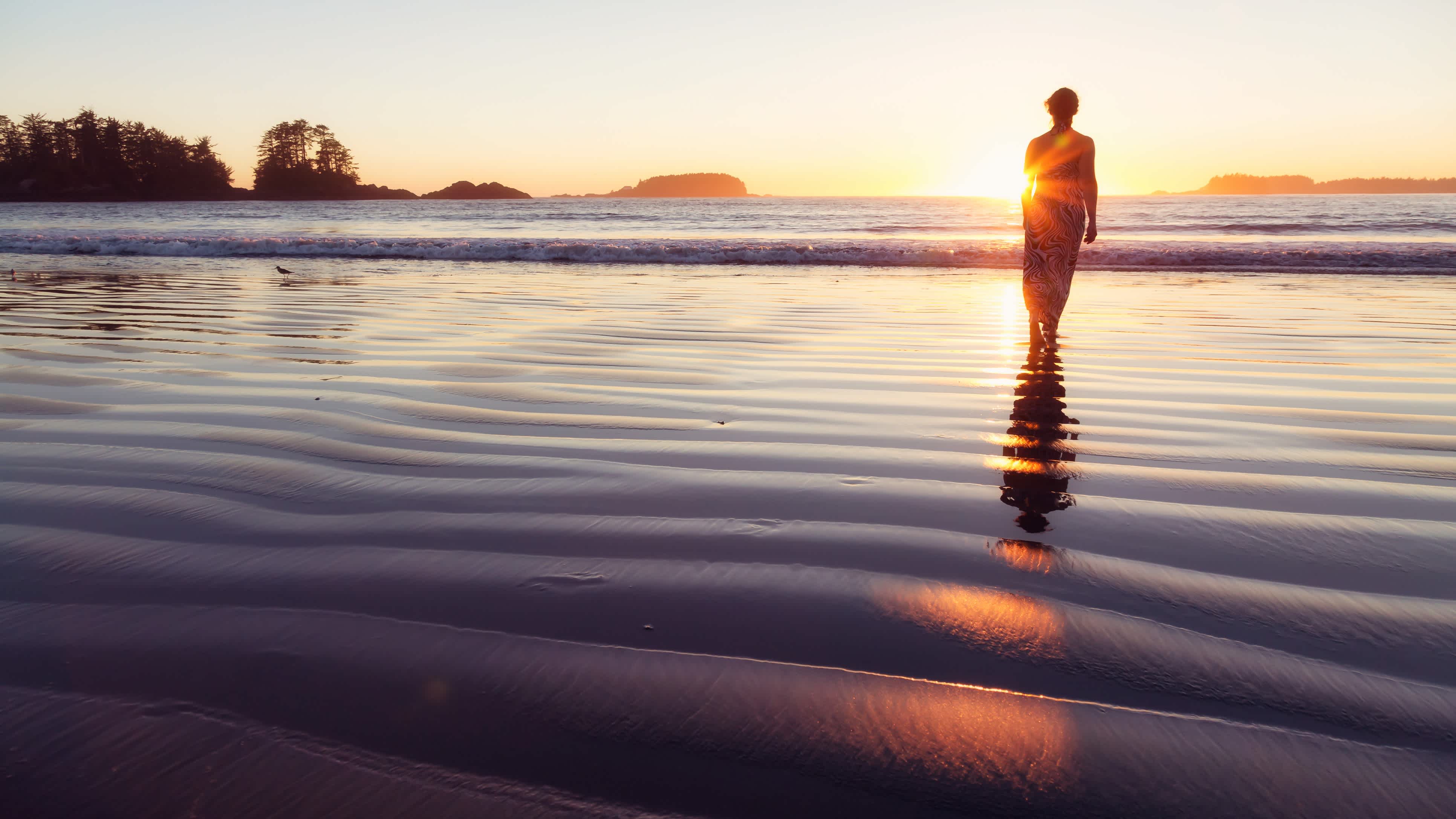 Femme marchant dans l'eau sur la plage de Chesterman Beach