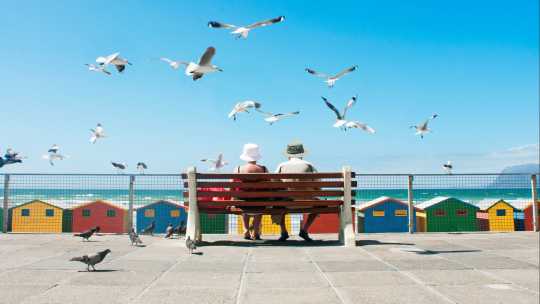 Ein älteres Paar genießt ein Mittagessen am Muizenberg Beach in Kapstadt, Südafrika.
