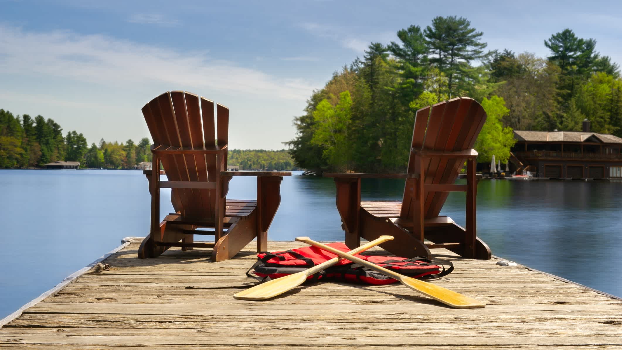 Zwei Stühle auf einem Holzsteg am See in Muskoka, Ontario, Kanada. 
