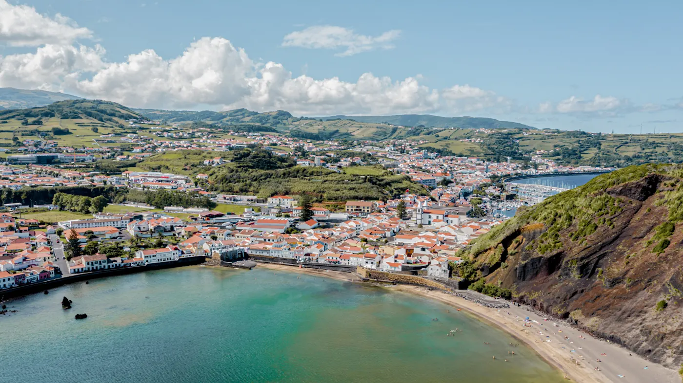Küstenstadt mit roten Dächern und Strand am Meer. Horta, Azoren, Portugal.
