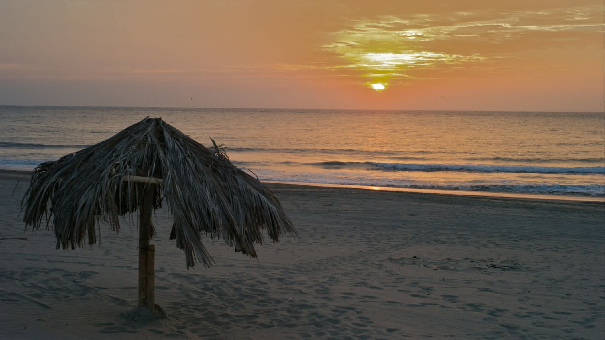 Der Strand von Vichayito in Mancora, Peru bei Sonnendämmerung und einem Strohsonnenhut.
