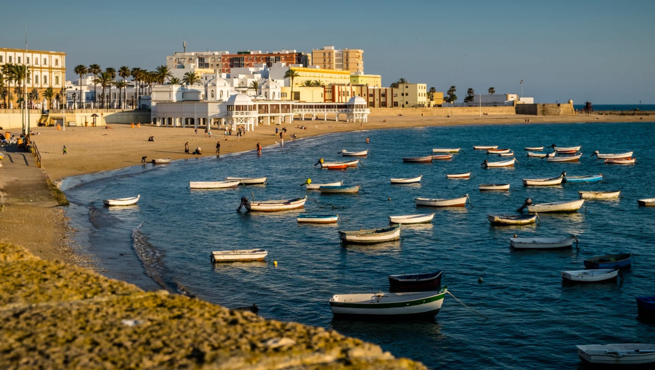 Bateaux sur l'eau au bord de la plage de La Caleta, au coucher de soleil, à Cadix, en Andalousie, en Espagne.

