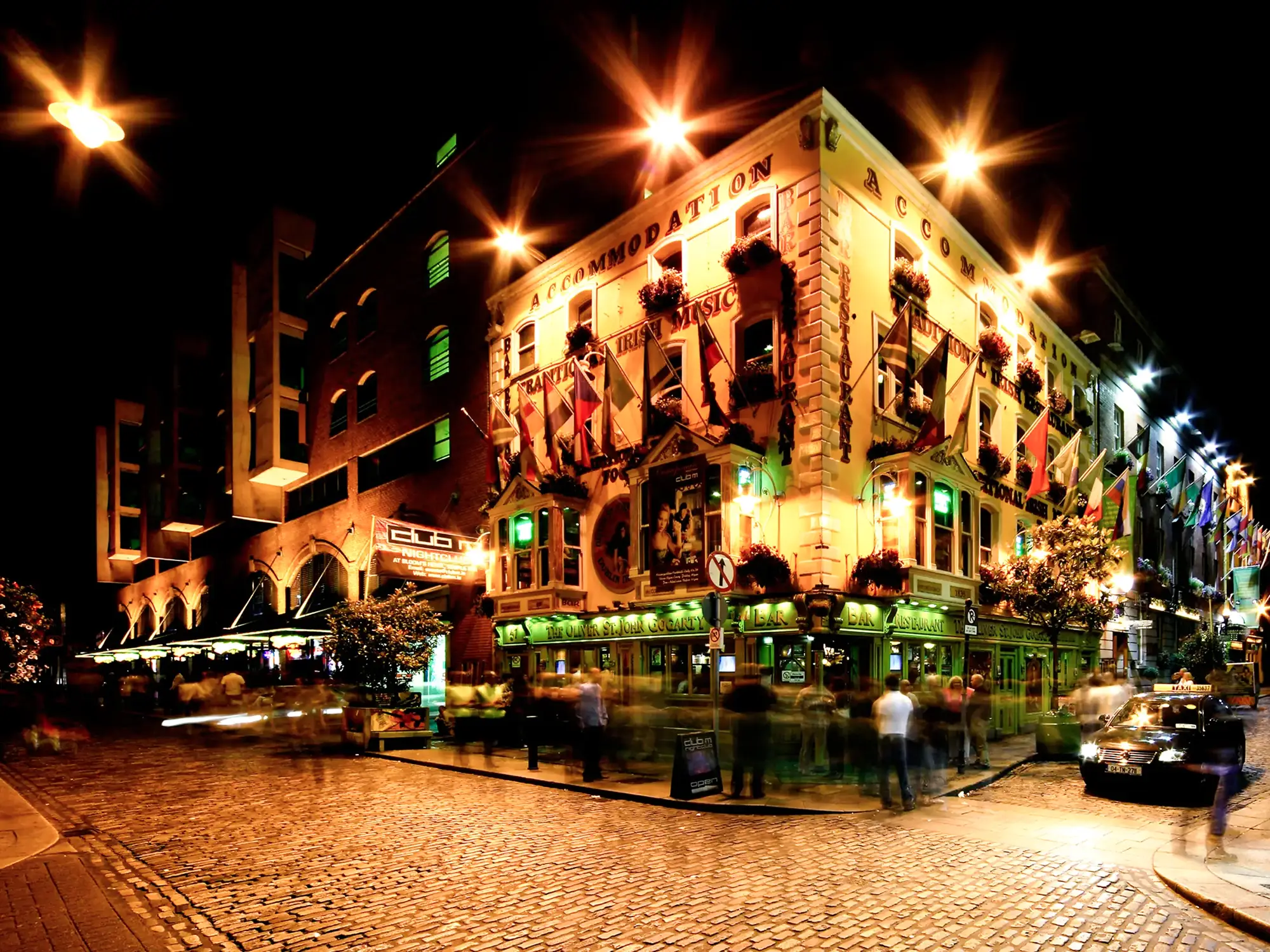 Lively street with pubs and lights at night. Belfast, Ireland.