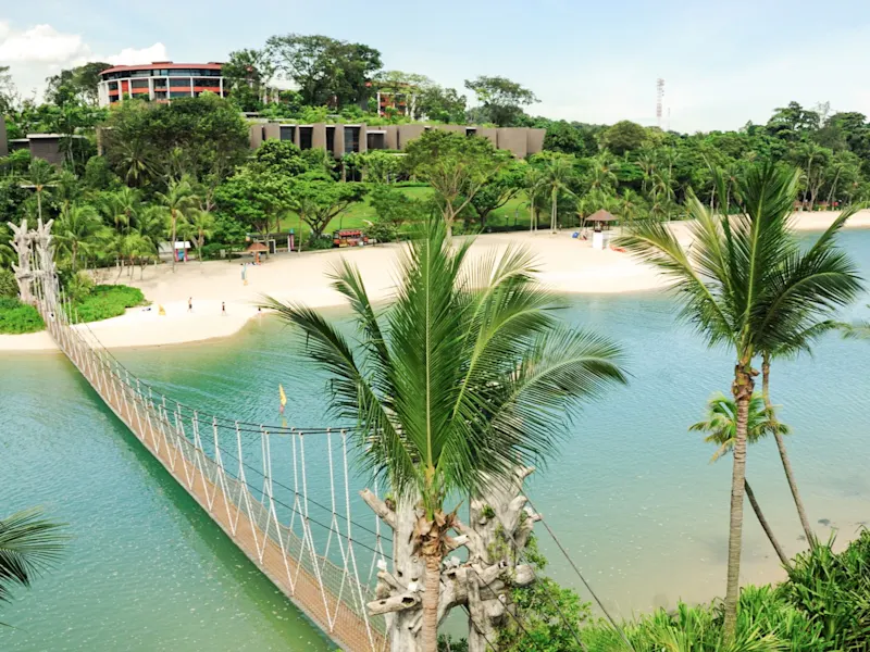 La plage de Palawan sur l'île de Sentosa à Singapour offre une pittoresque plage de sable blanc entourée d'eau turquoise et un pont unique qui mène à l'endroit le plus au sud du continent asiatique.