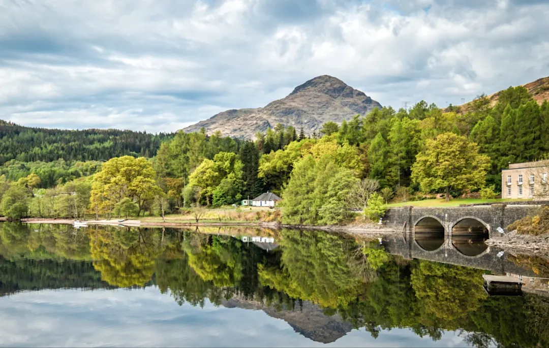 See mit Bergen und Brücke im Hintergrund. Loch Lomond, Schottland, Vereinigtes Königreich.