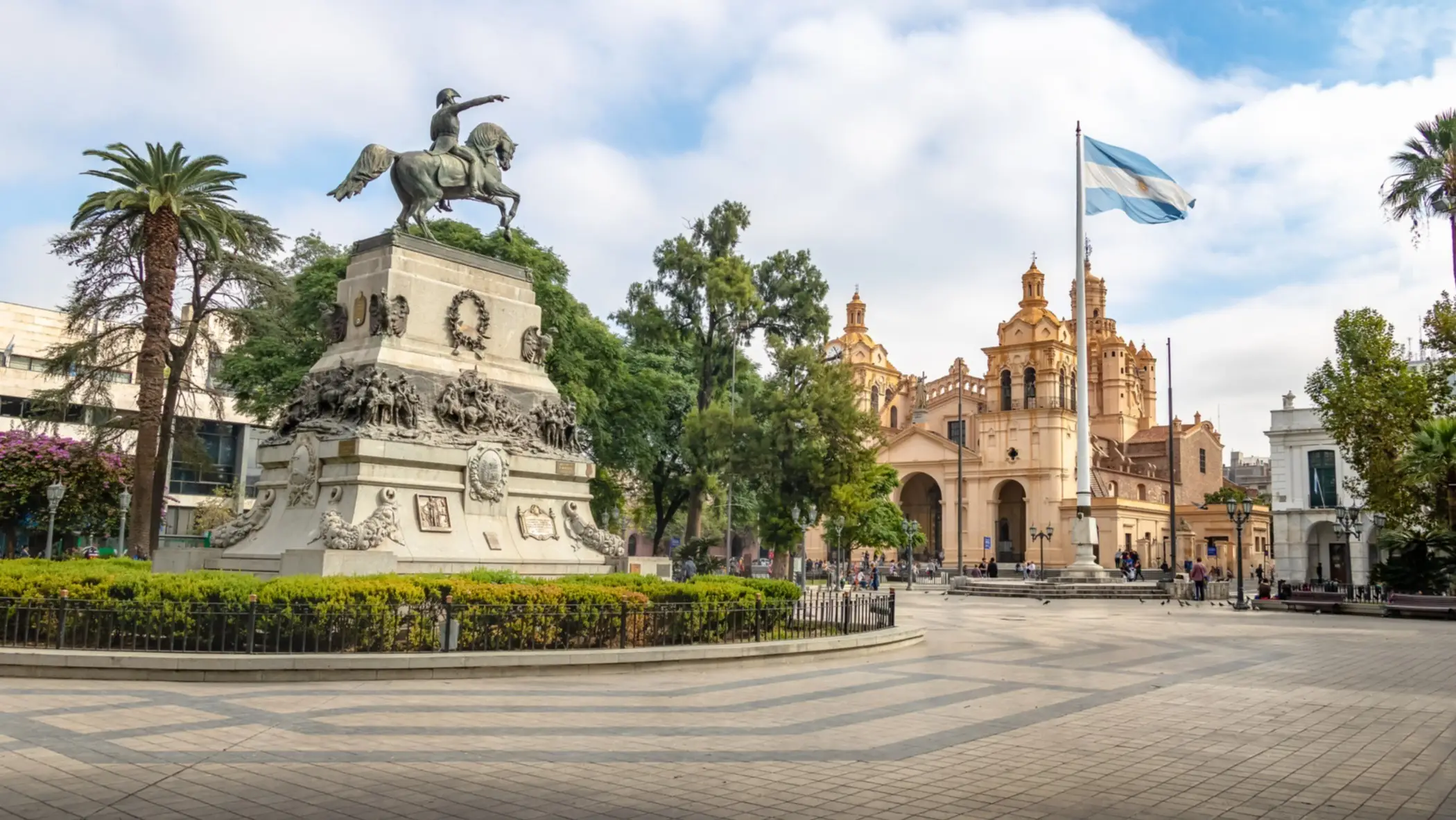 Une statue équestre au centre d'une place et le drapeau argentin, Córdoba, Argentine.