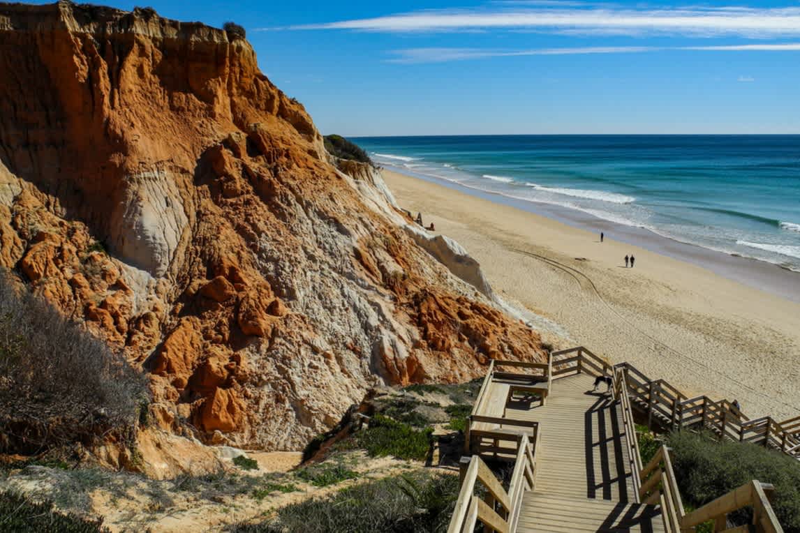 Breiter Sandstrand und Felsen in der Algarve