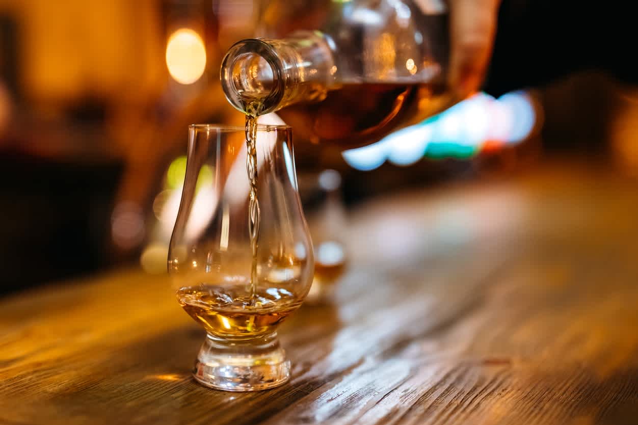 Gießen von Whiskey in Glas