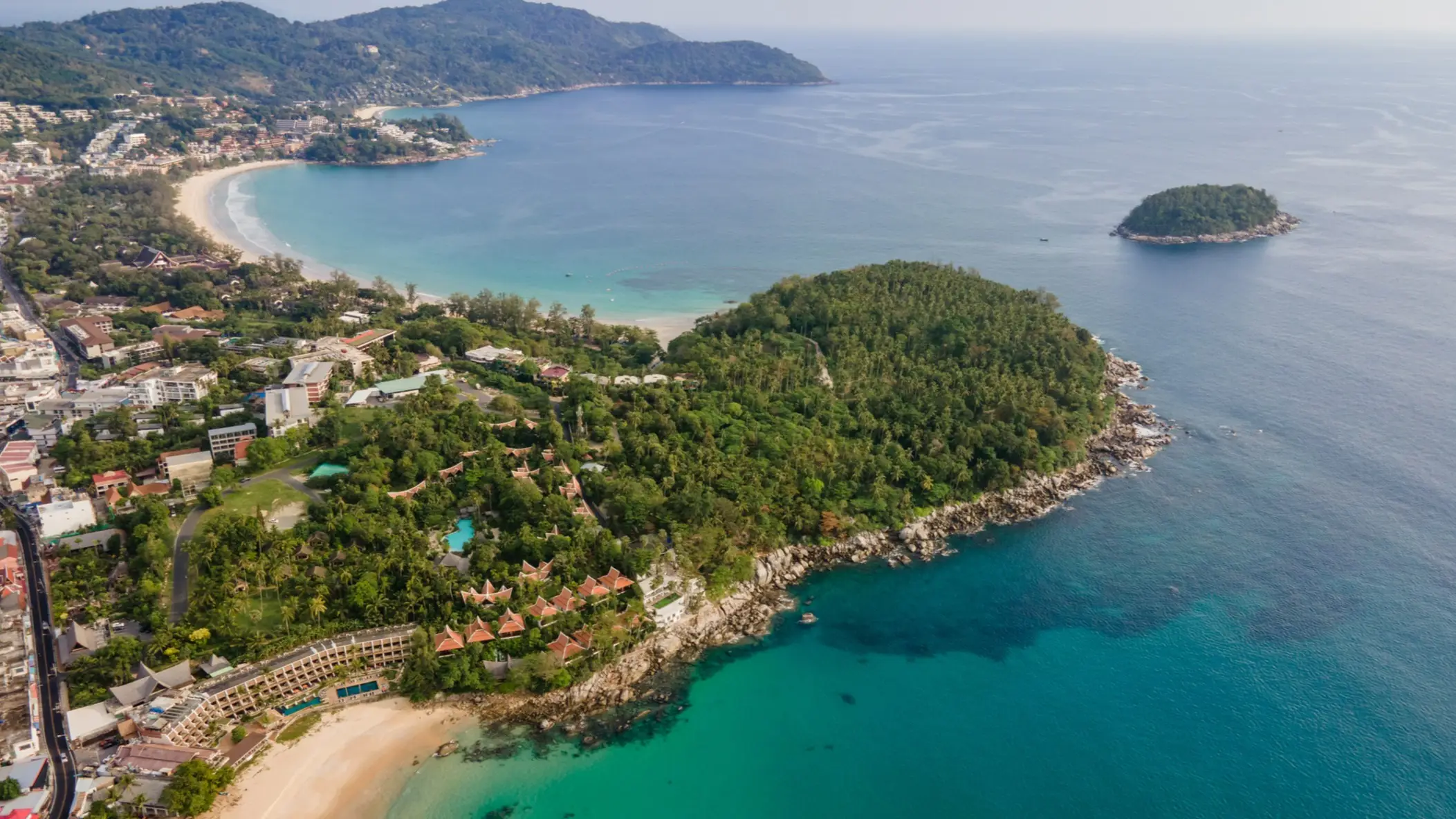 Thailand, Phuket, Karon Beach Luftaufnahme über dem Karon Beach, Phuket, mit Strandbuchten, grüner Hügelllandschaft und einem Teil der Stadt.