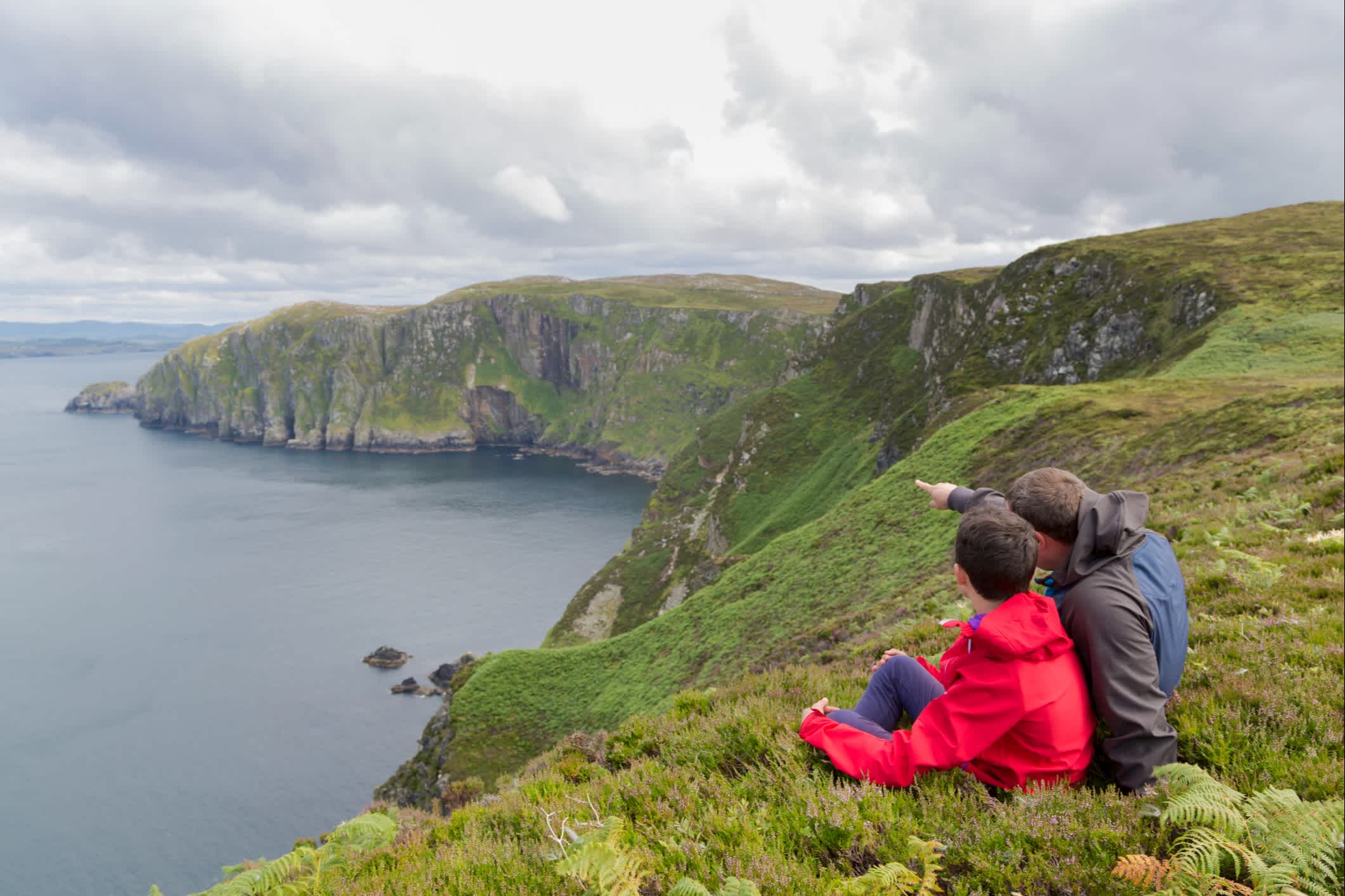 Vater und Sohn bewundern die Landschaft von Horn Head in Irland.
