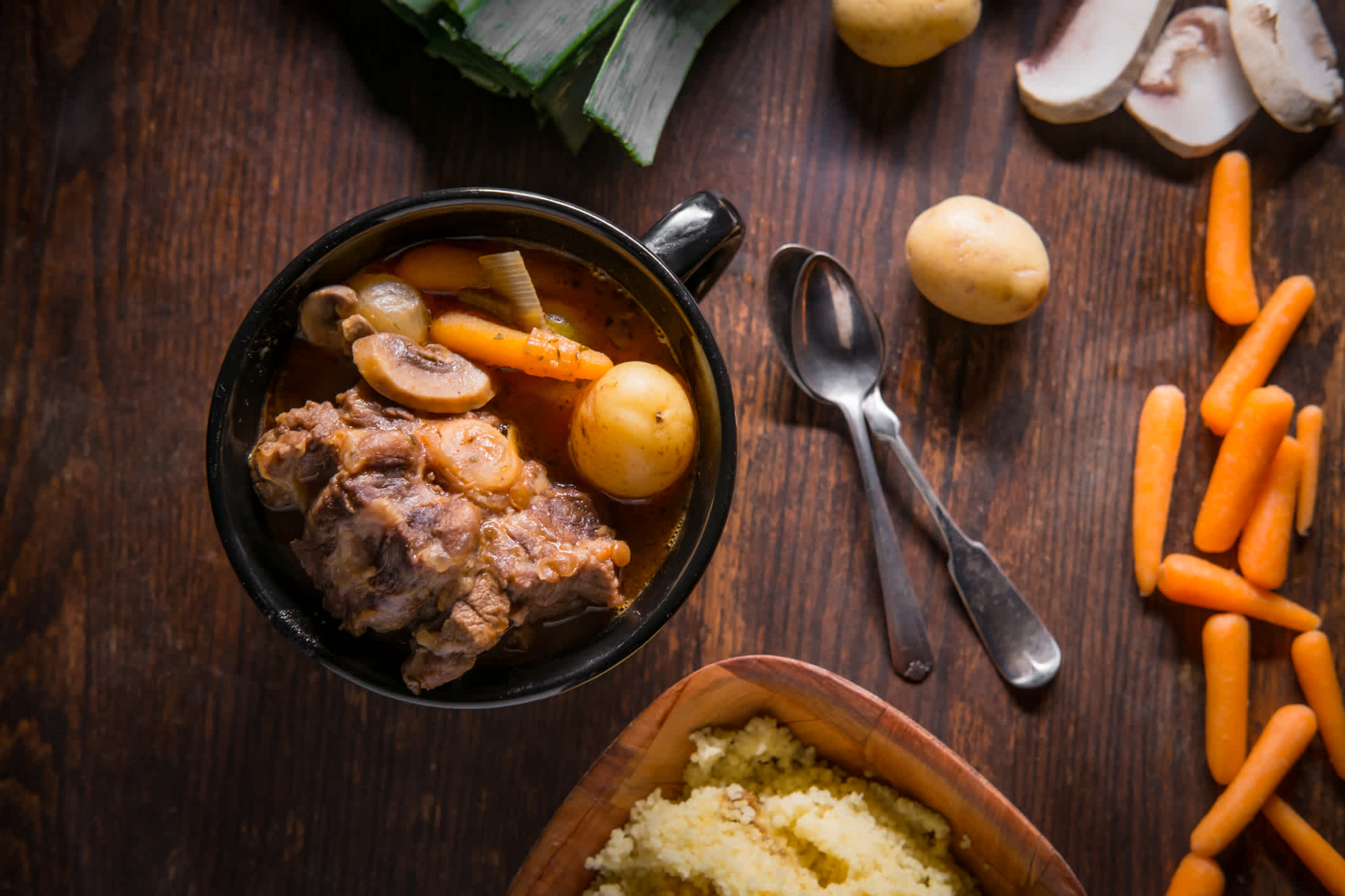 Potjiekos Südafrikanischer Ochsenschwanzeintopf mit Baby-Goldkartoffeln Karotten und ChampignonsPotjiekos Südafrikanischer Ochsenschwanzeintopf mit Baby-Goldkartoffeln, Karotten und Champignons