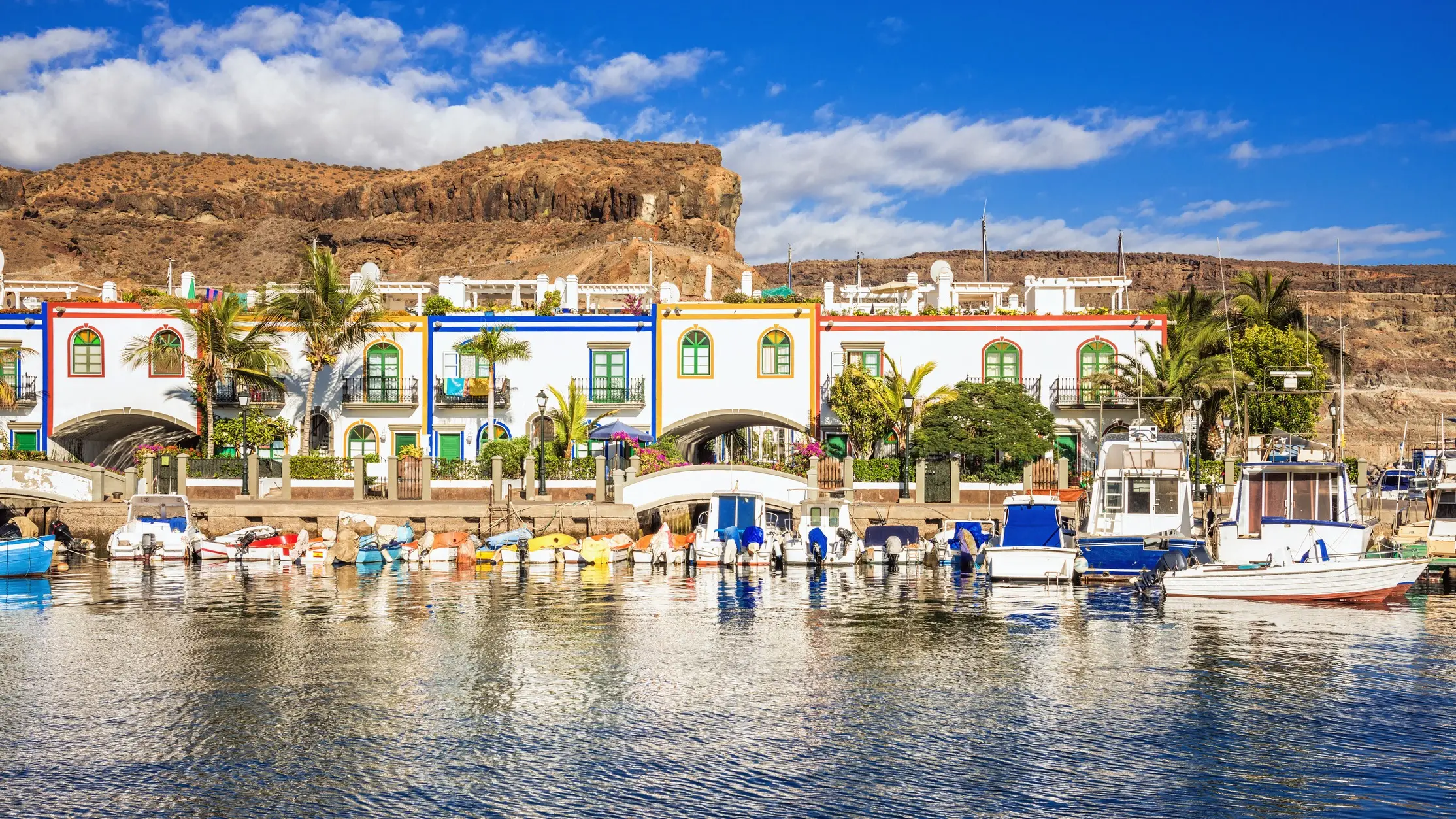 Bunte Häuser und Boote im kanarischen Stil im Hafen von Puerto de Mogan, Gran Canaria.

