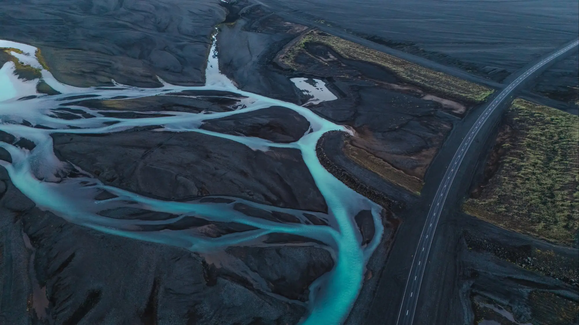 Vue aérienne des rivières tumultueuses et du sable volcanique le long de la route circulaire islandaise
