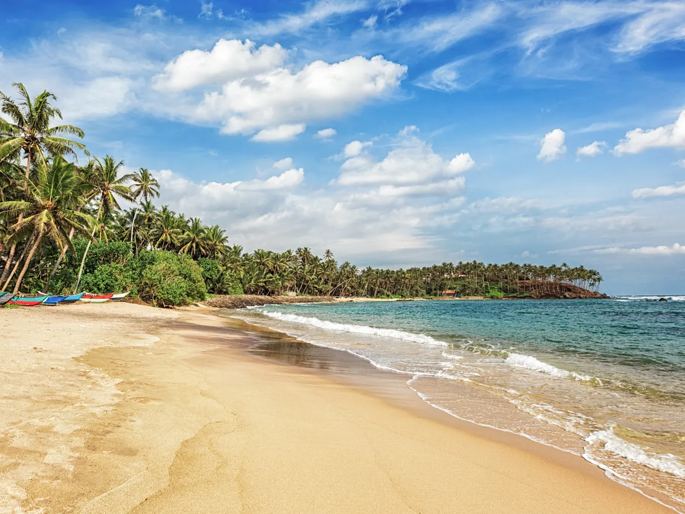 Mirissa-Strand, Sri Lanka Der Mirissa Strand in Sri Lanka begeistert mit goldenem Sand und türkisblauem Wasser, ideal zum Entspannen und für Bootsfahrten.