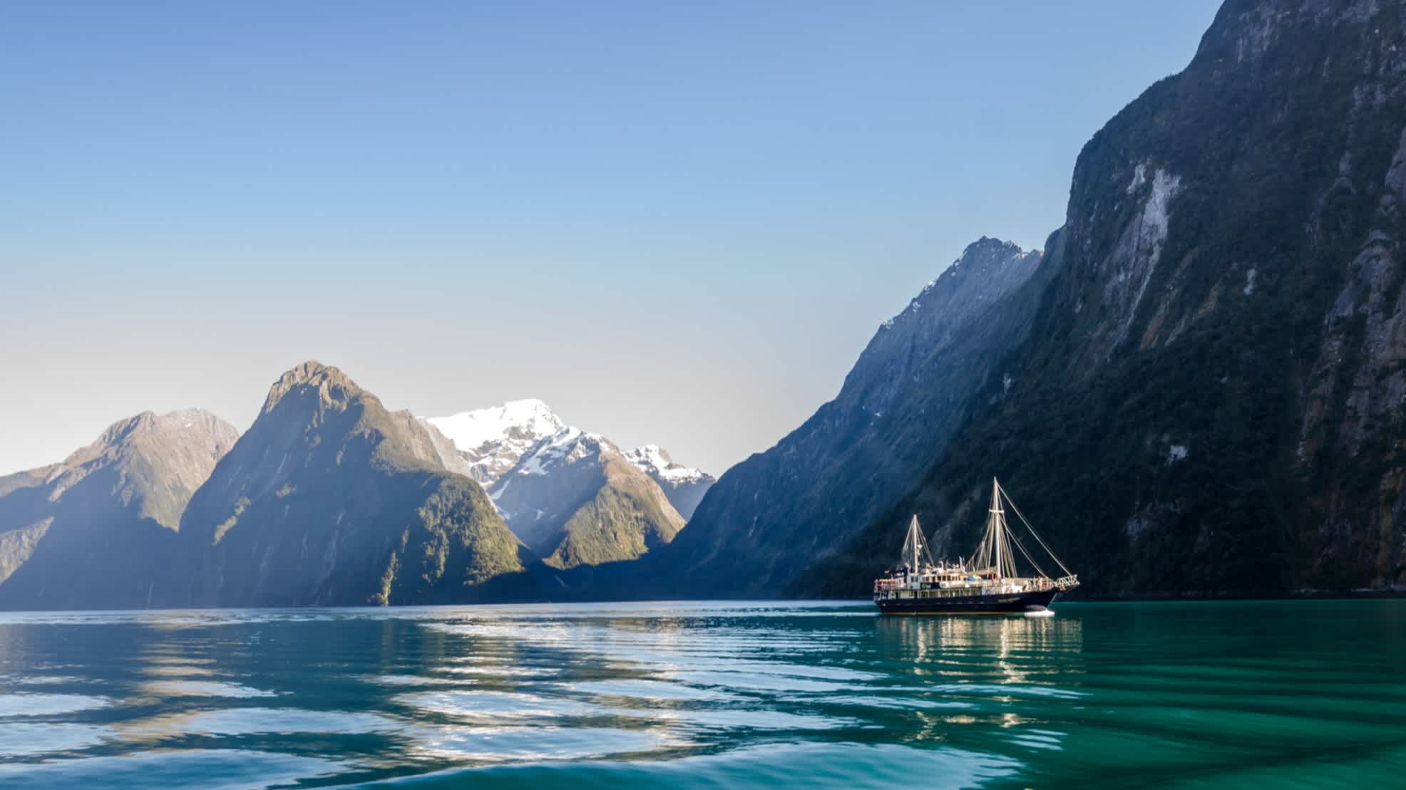 Milford Sound avec un bateau de croisière au lever du soleil, Nouvelle-Zélande.