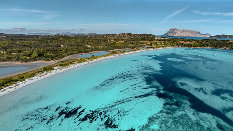 Cala Brandinchi in Sardinien ist bekannt für sein kristallklares Wasser und den feinen weißen Sand, der sich harmonisch in die umgebende mediterrane Landschaft einfügt