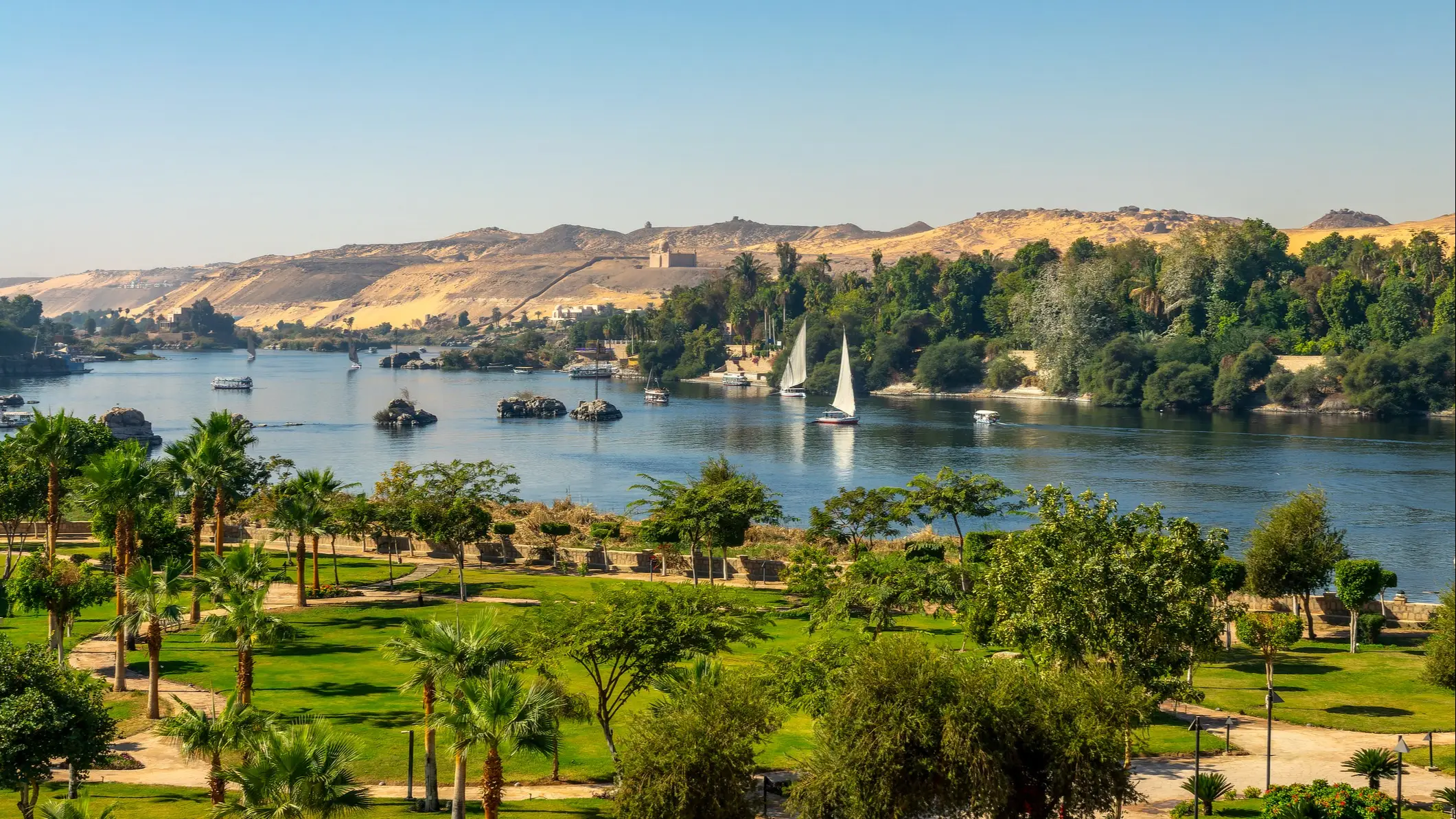 Luftaufnahme des Nils mit Feluken (traditionelle ägyptische Segelboote) in Assuan, Ägypten.

