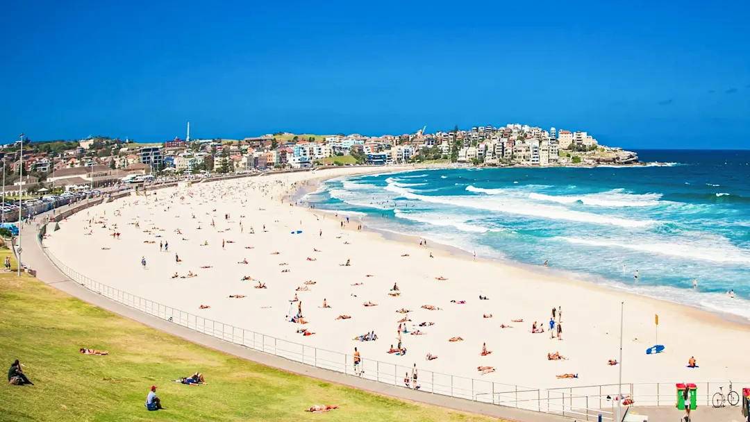 Bondi Beach mit Badenden und blauem Himmel. Sydney, New South Wales, Australien.