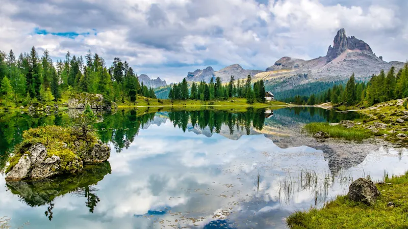 Felsige Berglandschaft mit See und Wald, Spiegelung im Wasser, Dolomiten, Südtirol, Italien.