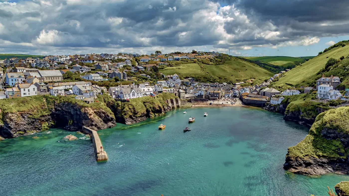 Küstendorf mit grünen Hügeln und Bucht. Port Isaac, Cornwall, England.