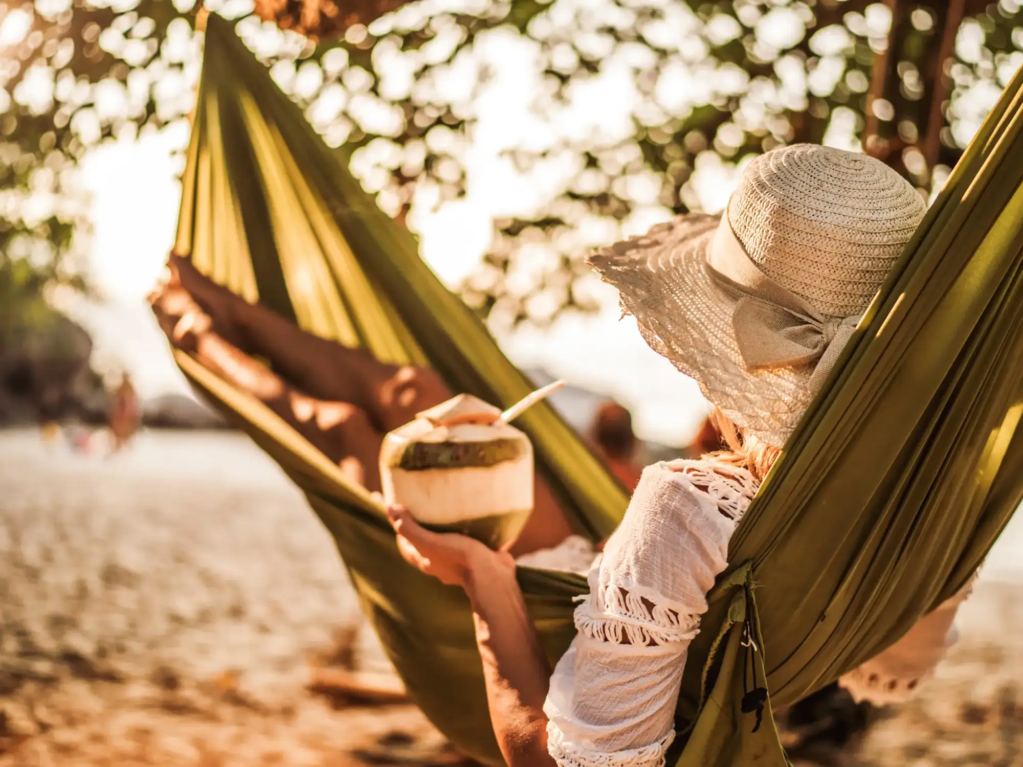 Femme dans un hamac avec une noix de coco sur la plage. Phuket, Sud de la Thaïlande