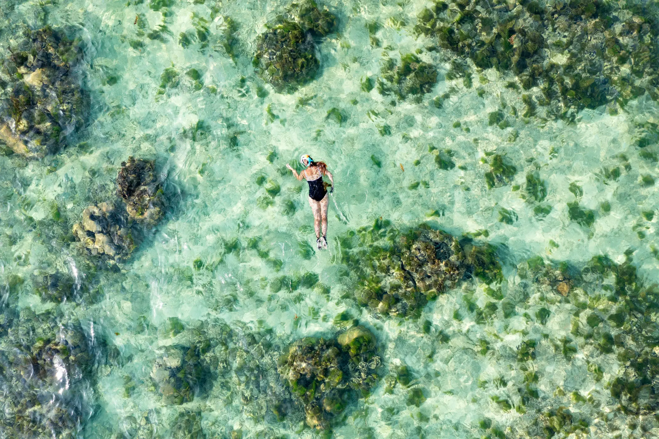 Korrallenriff Mauritius Luftaufnahme einer jungen Frau, die über dem Korallenriff schnorchelt